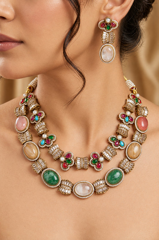 Close-up of model wearing Sabyasachi-inspired gold-plated multi-gemstone fusion necklace set with matching drop earrings.   