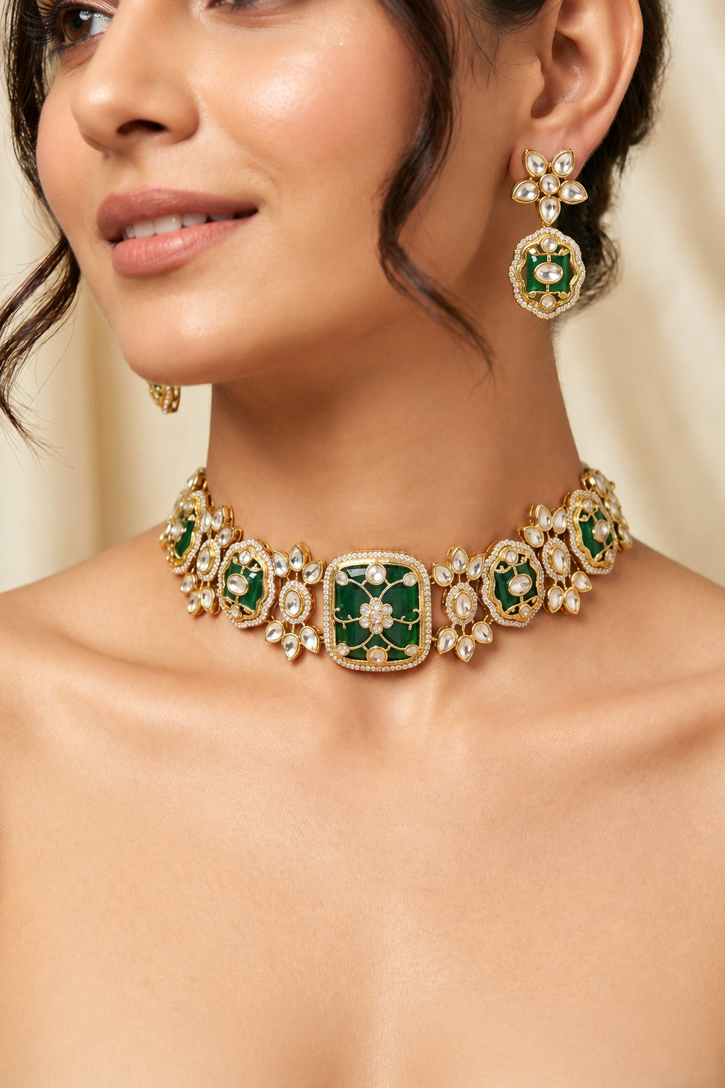 Close-up of model wearing Sabyasachi-inspired gold-plated emerald green choker necklace with Kundan polki floral motifs and matching drop earrings