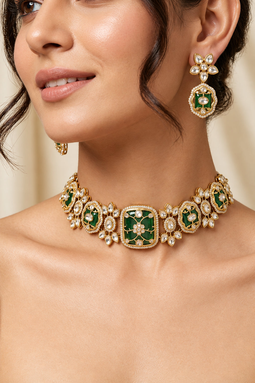 Close-up of model wearing Sabyasachi-inspired gold-plated emerald green choker necklace with Kundan polki floral motifs and matching drop earrings.