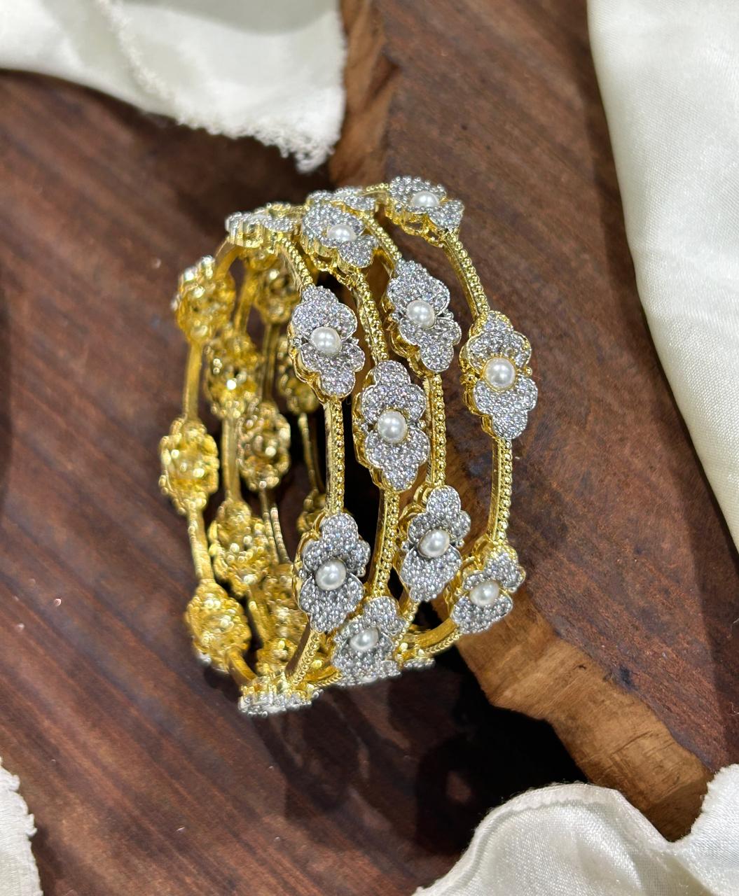 Bloom Pearl Bangles, pearl bangles, CZ pearl bangles, CZ bangles, pearl bangle set, South Indian bangles, South Indian jewellery, floral bangles, floral design bangles, dual tone bangles, gold plated bangles, rhodium plated bangles, gold and rhodium bangles, 4 piece bangle set, sleek bangles, traditional bangles, bridal bangles, wedding bangles, party wear bangles, festive bangles, designer bangles, Indian bangles, Pakistani jewellery, South Indian floral bangles