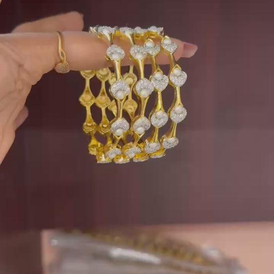 Pearl Petal Bangles, pearl bangles, CZ pearl bangles, CZ bangles, pearl bangle set, South Indian bangles, South Indian jewellery, floral bangles, petal bangles, floral design bangles, dual tone bangles, gold plated bangles, rhodium plated bangles, gold and rhodium bangles, 4 piece bangle set, sleek bangles, traditional bangles, bridal bangles, wedding bangles, party wear bangles, festive bangles, designer bangles, Indian bangles, Pakistani jewellery, South Indian floral bangles