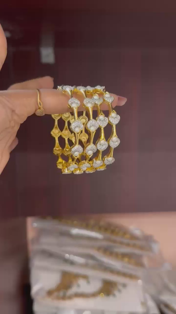 Pearl Petal Bangles, pearl bangles, CZ pearl bangles, CZ bangles, pearl bangle set, South Indian bangles, South Indian jewellery, floral bangles, petal bangles, floral design bangles, dual tone bangles, gold plated bangles, rhodium plated bangles, gold and rhodium bangles, 4 piece bangle set, sleek bangles, traditional bangles, bridal bangles, wedding bangles, party wear bangles, festive bangles, designer bangles, Indian bangles, Pakistani jewellery, South Indian floral bangles